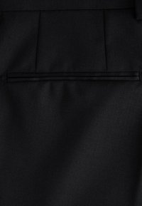 Tessuto nero con superficie strutturata, caratterizzato da una tasca orizzontale con cerniera e cuciture pulite, progettato per durabilità e stile.