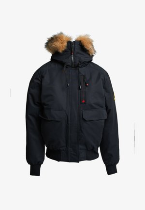 Czarna zimowa kurtka z kapturem wykończonym futrem, z przednim zamkiem błyskawicznym, dwiema dużymi przednimi kieszeniami i elastycznymi mankietami. Czerwone akcenty na zamku.