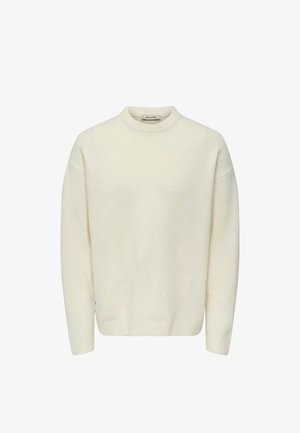 Suéter color crema con cuello alto, corte holgado y puños y dobladillo acanalados. Textura suave, mangas largas, diseño minimalista.