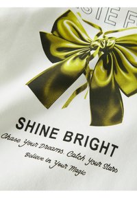 Valge kangas, millel on suur läikiv roheline vibu graafika ja allpool tekst: "SHINE BRIGHT" ning lisamotivatsioonilised fraasid musta värviga.