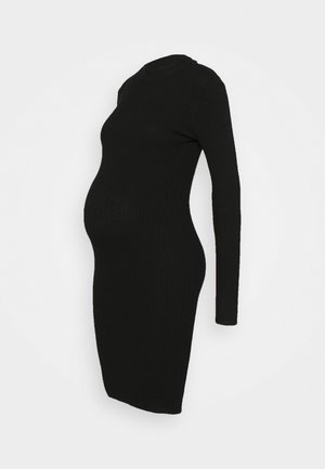 Czarna prążkowana sukienka ciążowa z długimi rękawami i dopasowaną sylwetką, zaprojektowana tak, aby pomieścić rosnący brzuch.