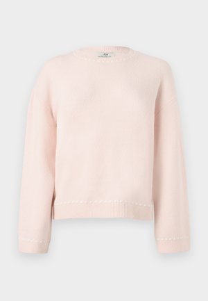 Myk lys rosa genser med lange ermer, rund hals og subtil ribbestrikket kant og mansjetter, vist mot en enkel lys grå bakgrunn.