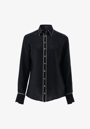 Navy blue linen shirt with long sleeves, white piping along the front and cuffs, and round buttons down the center.