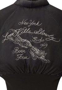 Černá saténová bomber bunda s vyšitým bílým tygrem a textem, s žebrovanými manžetami. Elegantní, strukturovaný tvar s vysokým límcem.