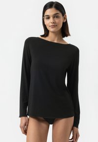 Haut noir à manches longues en tissu léger, avec un décolleté bateau et une coupe légèrement ample, doté d'une texture lisse et de détails de couture minimaux.