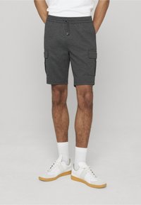 Shorts cargo gris avec taille à cordon, dotés de deux poches latérales. Portés avec des baskets blanches et des chaussettes blanches. Tissu texturé simple.