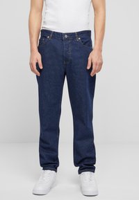 Jeans de mezclilla azul oscuro con un corte recto, cinco bolsillos y costuras claras. La parte delantera cuenta con un cierre de botón y cremallera.