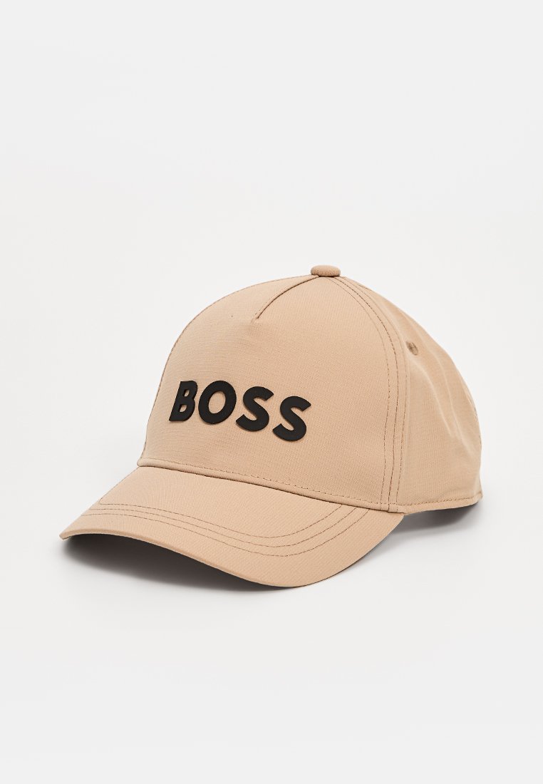 Casquette de baseball beige avec une visière incurvée portant un texte noir en gras "BOSS" sur le devant, présentée sur un fond blanc.
