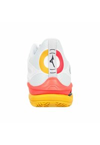 Scarpa da ginnastica bianca con tomaia testurizzata, dettagli rossi e gialli e un tallone multicolore. Include un logo sul retro.