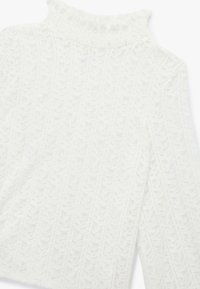 Valkoinen neulepaita, jossa on korkea ribattu kaulus ja tekstuurinen lehtikuvio koko paidan ajan. Pehmeä, kevyt kangas pitkillä hihoilla.