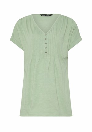 Jasnozielona bluzka z krótkim rękawem, dekoltem w serek, pięcioma guzikami z przodu oraz pionowymi plisami zdobiącymi przód i ramiona.