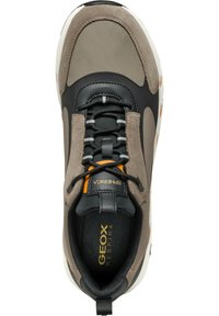 Sneaker grigio e nero con una combinazione di materiali in pelle e tessuto, dotato di una superficie testurizzata, dettagli arancioni e un design della suola a contrasto.