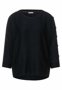 Svart, texturerad topp med rund halsringning och trekvartslånga ärmar som har dekorativa knappprydnader längs muddarna. Avslappnad passform.