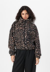 Fleece zip-up jacket featuring a black and peach leopard print, high collar, relaxed fit, and elasticized cuffs.