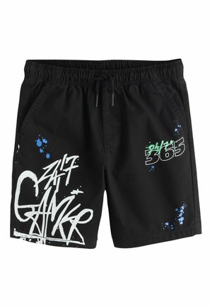 Black shorts with elastic waistband and drawstring, featuring white and green graffiti-style text "24/7 365" and blue paint splatter designs.