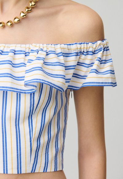 Top scollato con strisce blu, gialle e bianche; presenta un collo arricciato e un design aderente. Collana di perle dorate inclusa.