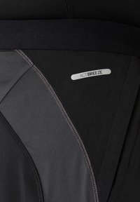 Zwarte activewear shorts met een brede tailleband, textuurstofpanelen en een reflecterend "ACTIBREEZE" label aan de zijkant.