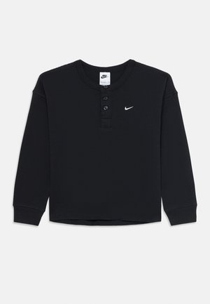 T-shirt henley à manches longues noir en maille gaufrée Nike avec trois boutons et un petit logo Swoosh Nike blanc sur la poitrine.