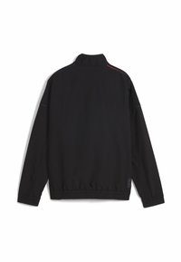 Svart jacka med hög krage, elastiska manschetter och fåll. Har kontrasterande röd och grå söm längs axlarna.