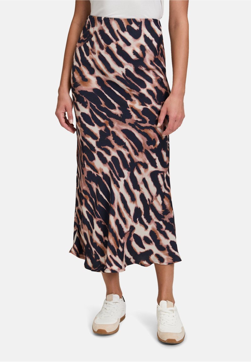 Jupe midi à imprimé léopard dans des tons marine, crème et pêche, fabriquée à partir d'un tissu doux et texturé avec une drapé délicat. Détail de fente latérale visible.