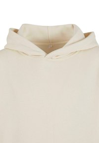 Krämfärgad hoodie med ett mjukt, texturerat tyg, en dra i huven och en enkel design utan mönster eller dekorationer.