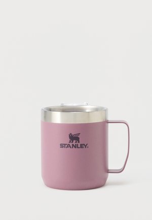 Cana Stanley din oțel inoxidabil mov, cu mâner și capac transparent, având un logo negru cu un leu cu aripi și textul „Stanley” în față.