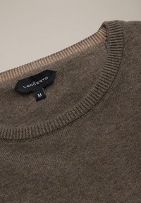 Brązowy sweter dzianinowy, okrągły dekolt, żebrowane mankiety, metka z nazwą marki "LANCERTO" i rozmiarem "M" widoczna. Miękka tekstura.