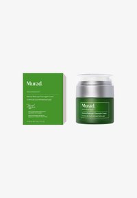 Crème de nuit Murad Retinal ReSculpt dans un pot vert opaque avec un couvercle argenté à côté d'une boîte verte assortie affichant un texte et des graphiques blancs.