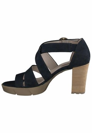 Sandał na wysokim obcasie z granatowego zamszu, z wieloma skrzyżowanymi paskami, otwartym palcem i beżowym, teksturowanym blokowym obcasem z poziomymi rowkami.