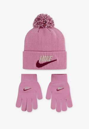 Růžová pletená čepice s bambulí a ohnutým lemem, zdobená texturovaným logem "Nike". Odpovídající růžové pletené rukavice se podobnými akcenty loga.