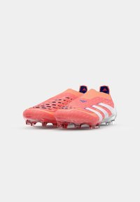 Scarpe da calcio arancioni brillanti con superficie texturizzata, strisce bianche e una tomaia in rete traspirante. Presenta tacchetti trasparenti per la trazione.