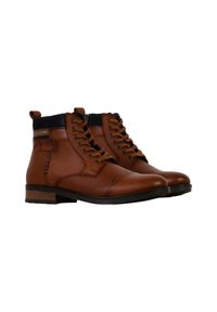 Botas de cuero marrón hasta el tobillo con cuellos acolchados negros, frentes con cordones y tacones bajos apilados, mostradas una al lado de la otra sobre un fondo blanco.