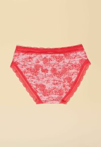 Rote Slips mit Spitzenbesatz, die aus einem pinkfarbenen gemusterten Stoff bestehen, der Szenen von Bäumen, Booten und tropischen Elementen zeigt.