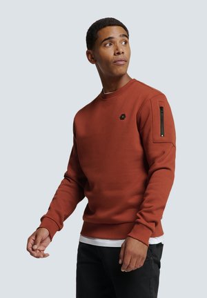 Roestkleurig sweatshirt met lange mouwen, ribgebreide boorden en een ritszak op de linkerarm. Voorzien van een klein logo op de borst.