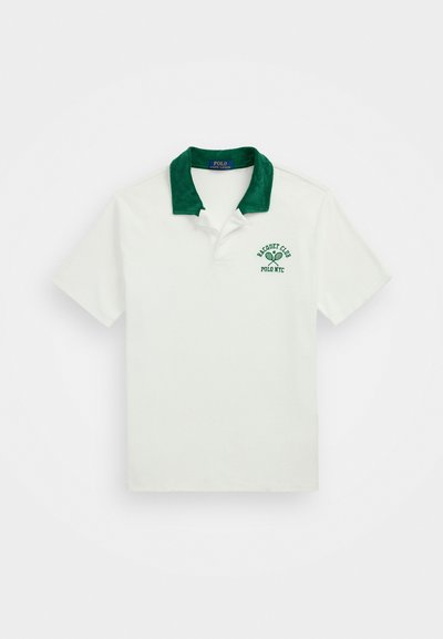 Λευκό πόλο μπλουζάκι με πράσινο βελούδινο γιακά. Διαθέτει γραφικό με ρακέτα τένις και κείμενο "Racquet Club Polo NYC" σε πράσινη κεντημένη εκδοχή.