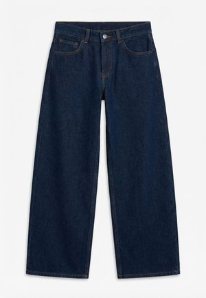 Mørkeblå vidbente jeans i denim med knapp og glidelås foran, beltehemper og fem-lommers design, lagt flatt på hvit bakgrunn.