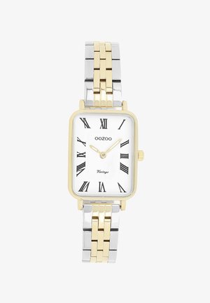 Montre rectangulaire en or et argent avec un cadran blanc, des chiffres romains noirs et un bracelet en métal bicolore. Marque : Oozoo.