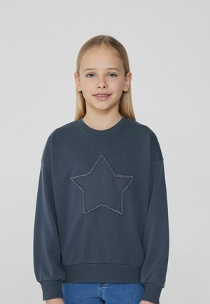 Dunkelgrauer Kapuzenpullover mit einem großen Stern-Design und strukturierten Kanten. Weiches Material, lockere Passform sowie gerippte Bündchen und Saum.