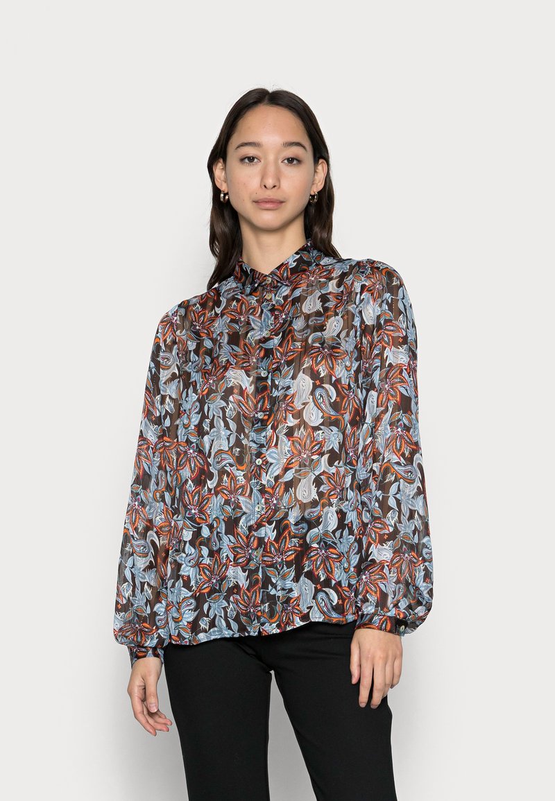 Blusa transparente de manga longa com padrão floral em vermelho, azul e branco sobre um fundo preto; apresenta fecho de botões na frente e gola mandarina.