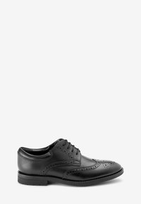 Chaussure brogue en cuir noir avec perforations décoratives, design à lacets, bout rond et talon bas. Texture lisse et silhouette classique.