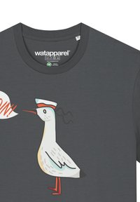 Graues Baumwoll-T-Shirt mit einem Cartoon-Möwe, die einen Matrosenhut trägt und rot-orangene Akzente hat, mit der Aufschrift "AHOY!" in einer Sprechblase.