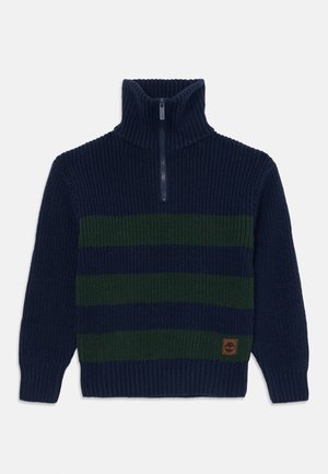 Pull en maille navy avec des rayures horizontales vertes, col haut et demi-zip. Équipé de poignets et d'ourlet côtelés, ainsi que d'une petite patch logo.