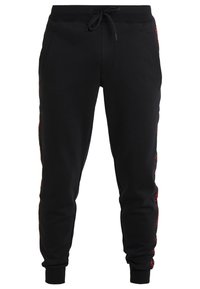 Schwarze Sweatpants mit Kordelzugbund, roten Seitenakzenten und zwei Fronttaschen; aus weichem, strukturiertem Stoff gefertigt.
