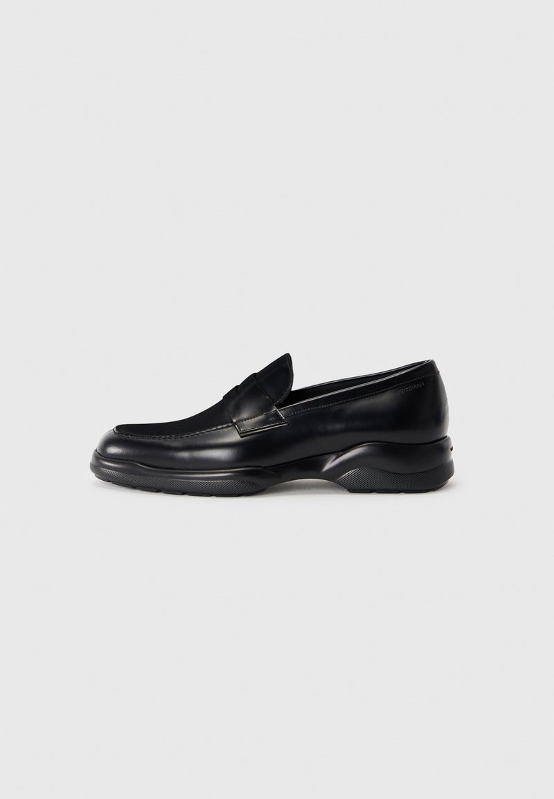 Zwarte leren loafers met een lage, gestructureerde rubberen zool en een gestikt ontwerp op het bovengedeelte. Beschikt over een afgeronde neus en minimale versieringen.