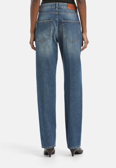 Jeans de tiro alto y pierna ancha en denim, con dos bolsillos traseros y una etiqueta de marca de cuero en la parte trasera de la cintura.