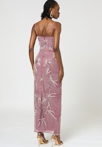 Abito da sera in rosa polveroso con accenti argentati, corpetto aderente e gonna fluente. Presenta spalline sottili e intricati motivi floreali.