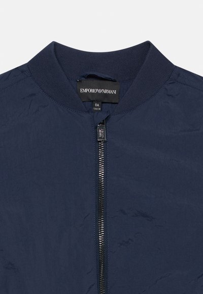 Μπλε ναυτικό μπουφάν Emporio Armani με ριμπ γιακά, εμπρόσθιο μεταλλικό φερμουάρ και ετικέτα μεγέθους που δείχνει 8A (130 εκ).