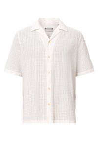 Chemise blanche à manches courtes texturée, boutonnée, avec col camp et cinq boutons beiges sur le devant au centre.