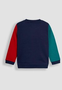Sudadera multicolor con un cuerpo en azul marino, una manga izquierda roja y una manga derecha color teal. Material de punto texturizado con puños y cuello acanalados.