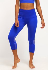 Blauwe sportlegging met hoge taille, capri-lengte, zijpanelen van gaas en een gladde textuur, geschikt voor sportkleding.
